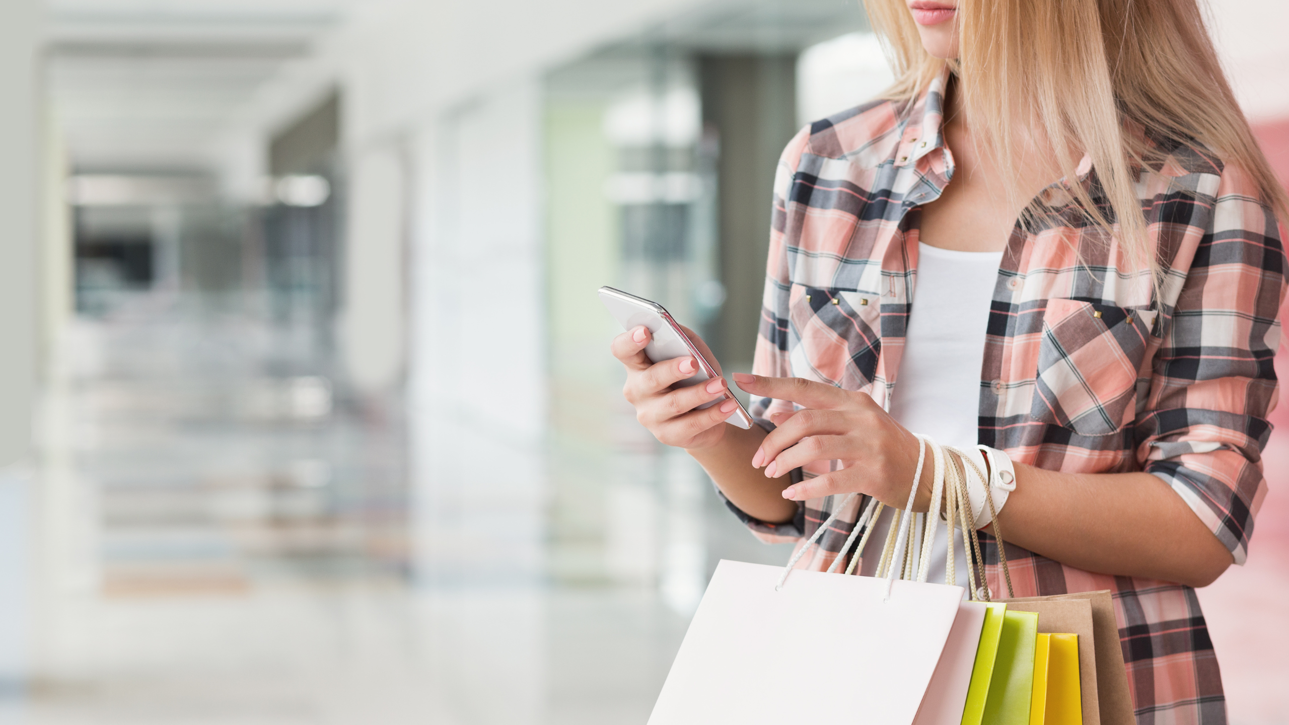 woman texting on phone while in the mall