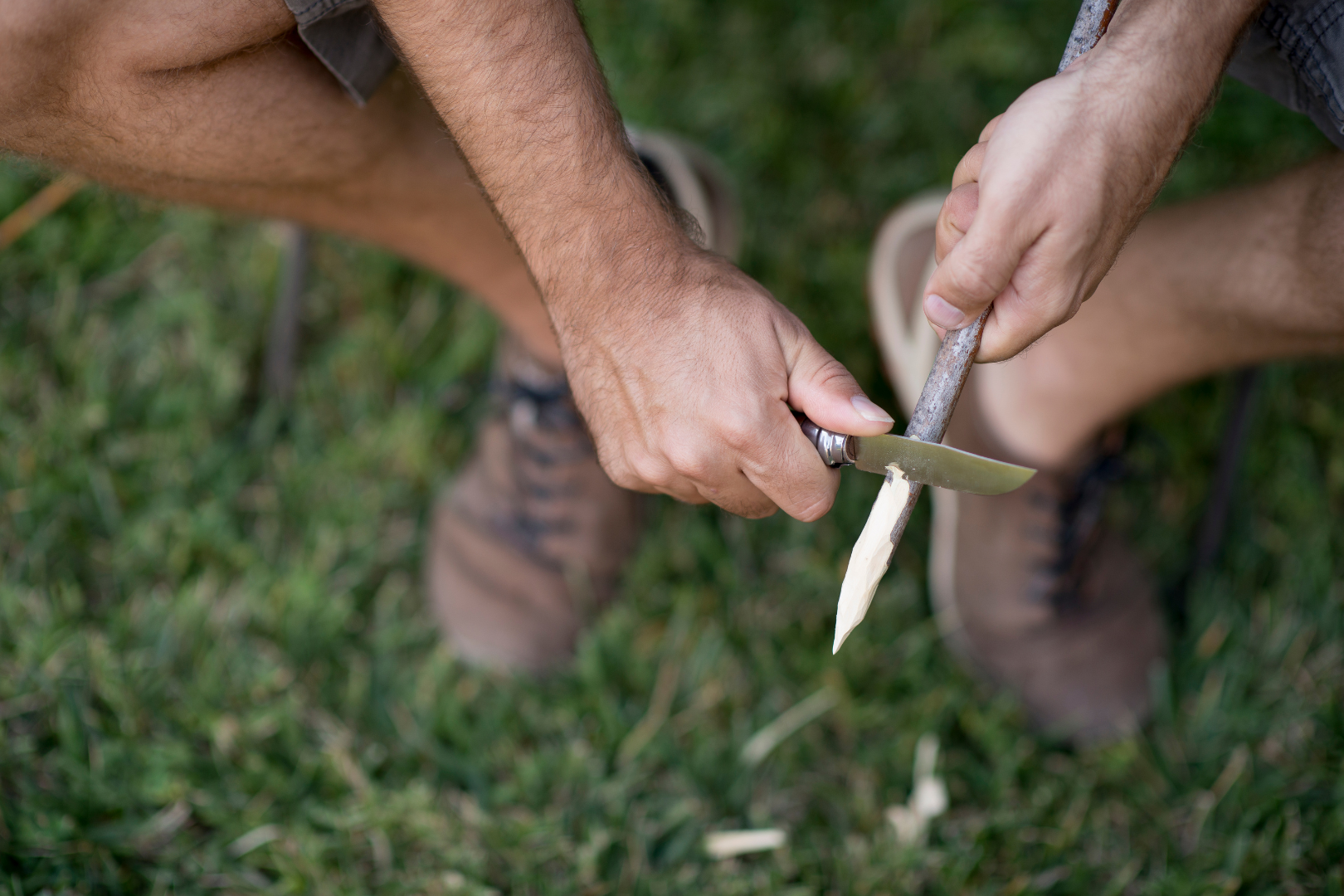 whittling a wooden stick into a pointed utensil