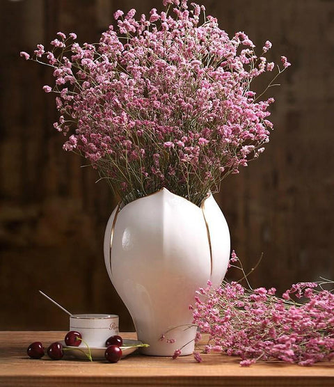 Blue jug vase with bulk gypsophila dried white flowers Stock Photo