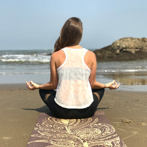 Girl meditating on the beach peacefully