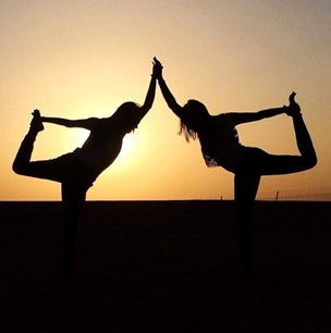 Two Yogis Doing Yoga At Sunset
