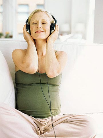 Pregnant woman relaxing to music