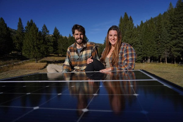 A couple sitting near the BougeRV 200W solar panel