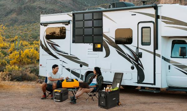 A man and a woman RV camping using BougeRV’s foldable solar panel, camping fridge and portable air conditioner&nbsp;