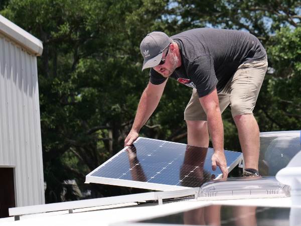 A man installing BougeRV solar panels
