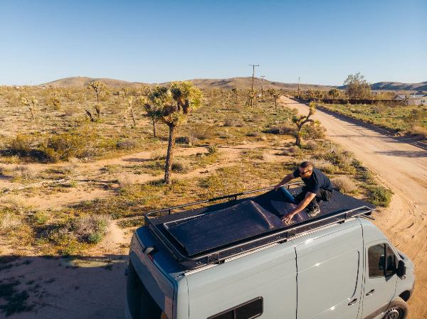 A man installing a BougeRV’s hail-resistant flexible CIGS solar panels on the RV