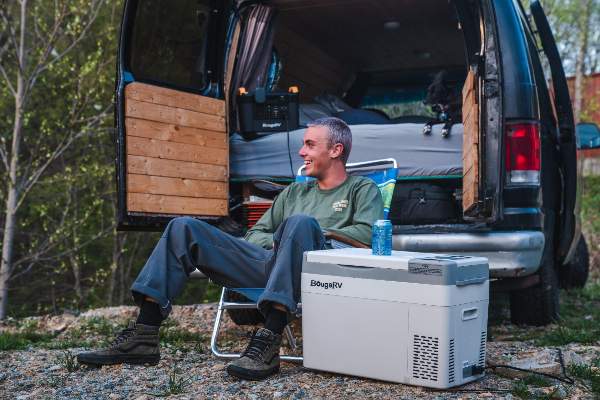 A man is RV camping with BougeRV’s 12V compressor fridge