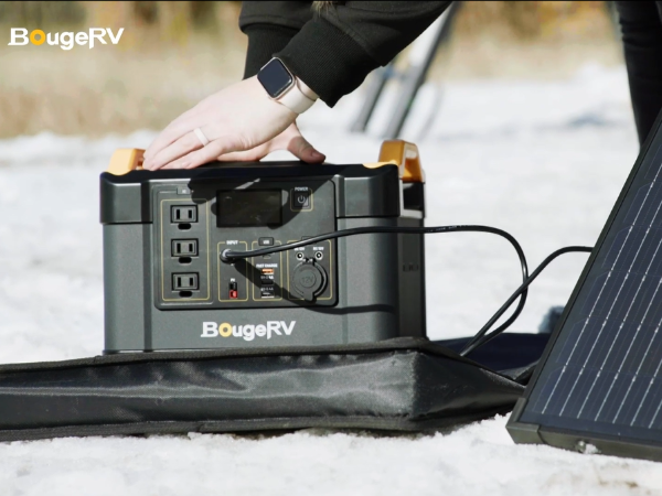 A woman charging a BougeRV solar panel using a BougeRV portable power station