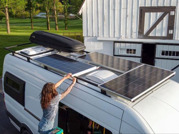 A woman installing BougeRV’s hail-resistant rigid Monocrystalline solar panels on the RV roof