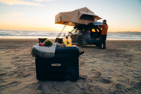 Man car camping on the beach using BougeRV’s 12V electric cooler