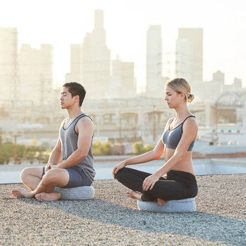 Two people outside using their Crystal Cove Oval Meditation Pillow