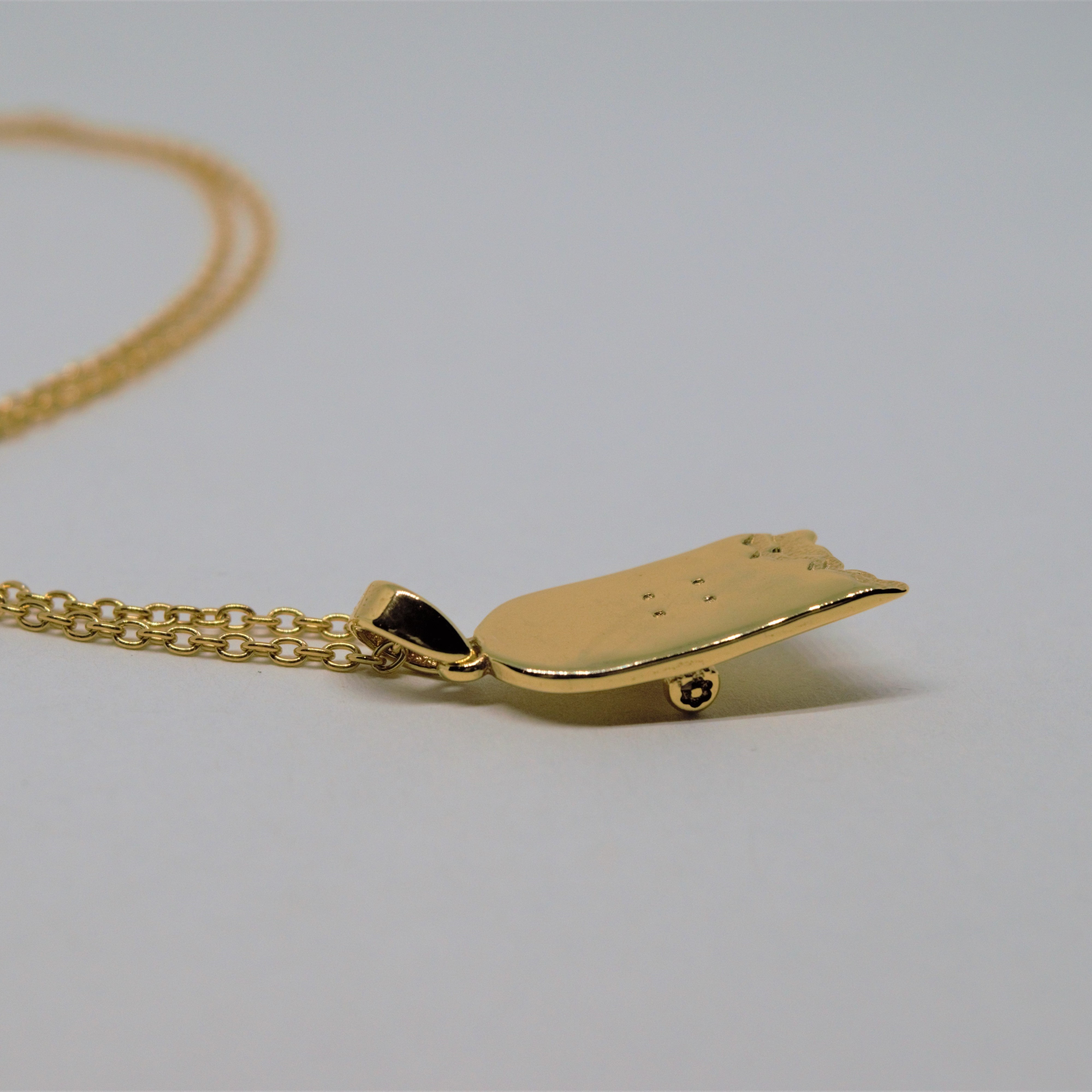 gold skateboard pendant