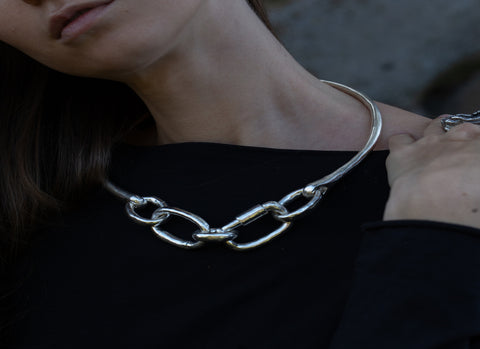 woman in black wearing a chunky chain link necklace
