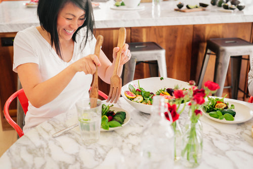 a-woman-using-salad-servers-to-load-her-plate-with-2023-11-27-04-53-43-utc.jpg__PID:0c117155-9df9-4651-a79a-fc5dcf7843a8