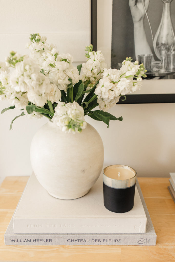 red currant collection candle on table next to flowers