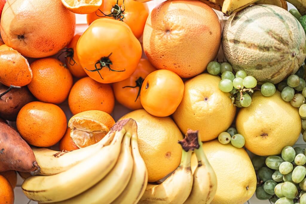 Prebiotic-rich fruits including bananas, oranges, grapes, and melons