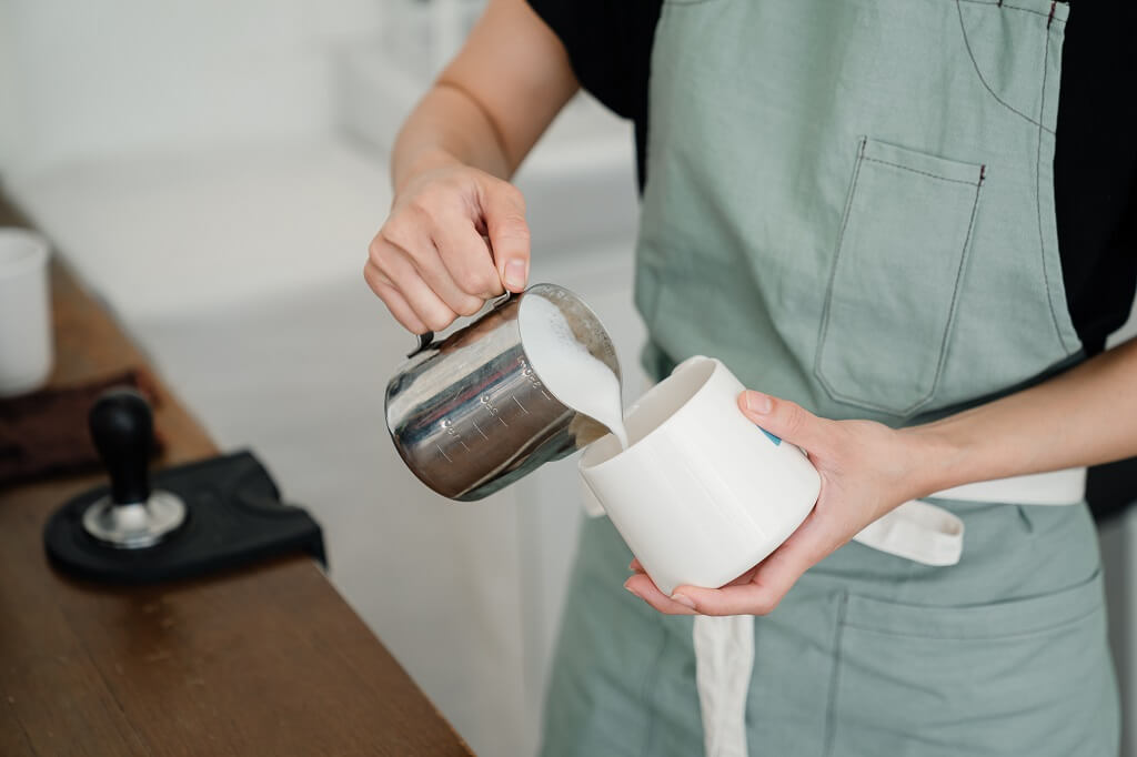 Barista steaming milk which requires digestive enzymes to break down