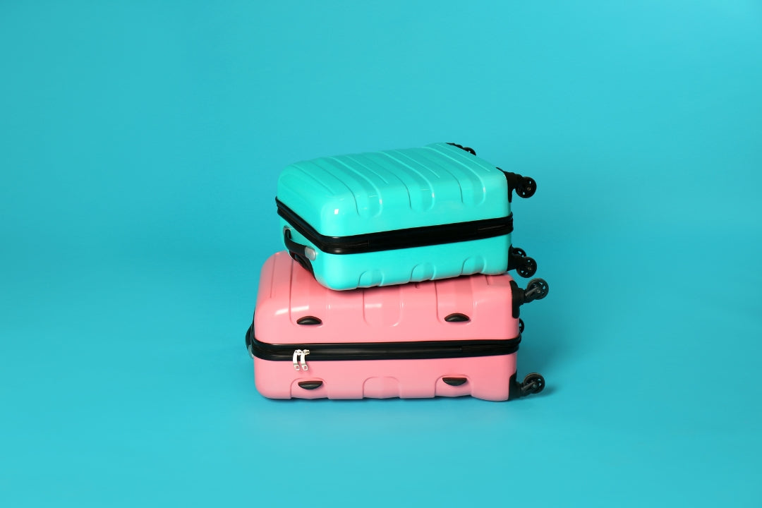 blue carry on stacked on pink one