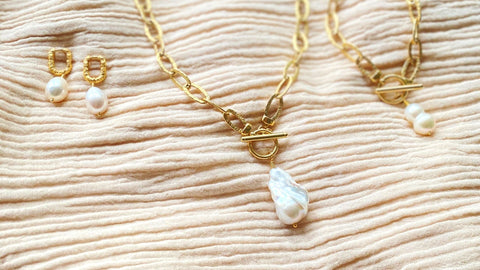 Treat yourself or a love one to something special this valentines like a beautiful cultured freshwater pearl necklaces or earring from RAW Copenagen.Image of cultured freshwater pearl jewellery designs by RAW Copenhagen resting on a cotton cloth