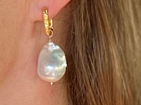 Baroque pearl earrings from RAW Copenhagen, made with big pearl and textured gold hoop, modelled from the side on sun kissed skin against long blond hair