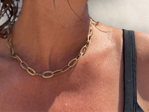 Chunky chain gold necklace with a hammered texture, modelled with a black bikini top against sun kissed skin