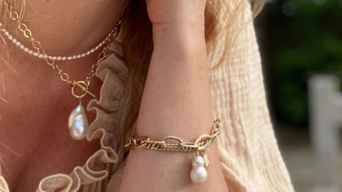 Image of the gold vermeil and freshwater pearl designs by RAW Copenhagen here modelled on wrist and neck on a summers day in Kent