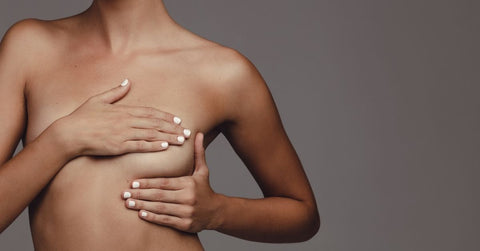 Image of a woman doing self examination of her breast for early detection of breast cancer, RAW Copenhagen is donating money to BREAST CANCER NOW during breast cancer awareness month of October 2021 through the sale of hoop earrings