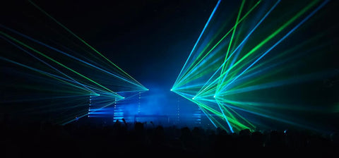 Colorful laser beams project over the audience