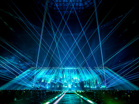Beams of blue light shines over the crowd and into the sky