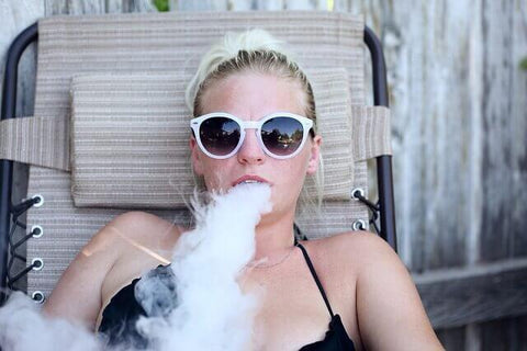 woman vaping in lounge chair