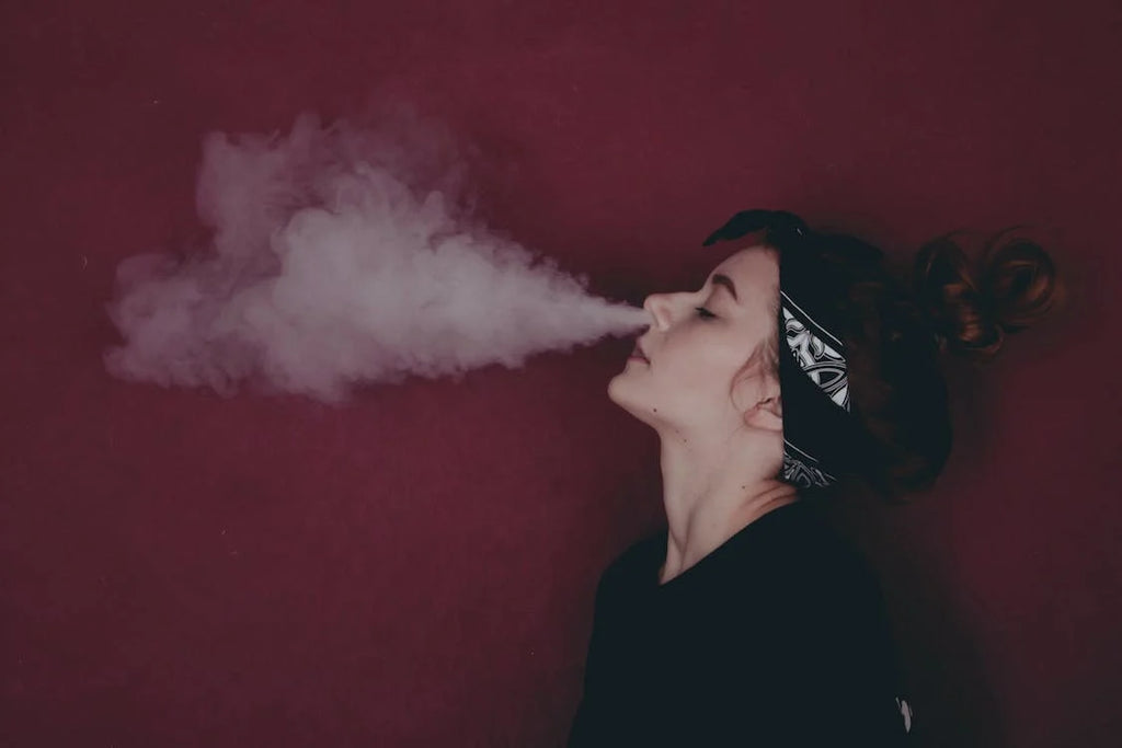 woman with bandana exhaling smoke through her nose