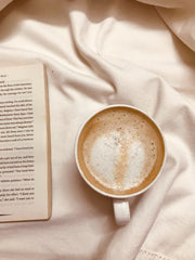 Close-up photo of espresso drink, book and blanket