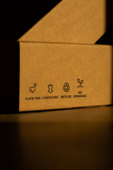 Close-up of a cardboard box with graphic symbols showcasing its sustainability attributes.
