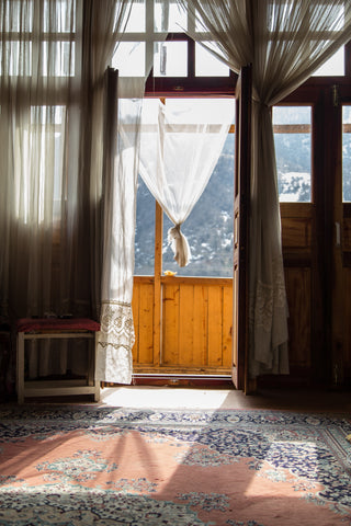 Photo of a daylight filled space, window curtains and area rug