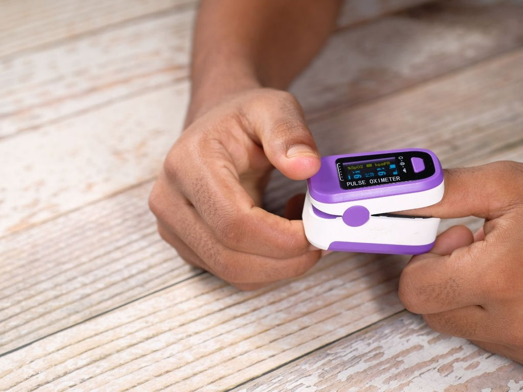 Person measuring blood oxygen saturation at home using Fingertip Pulse Oximeter - 