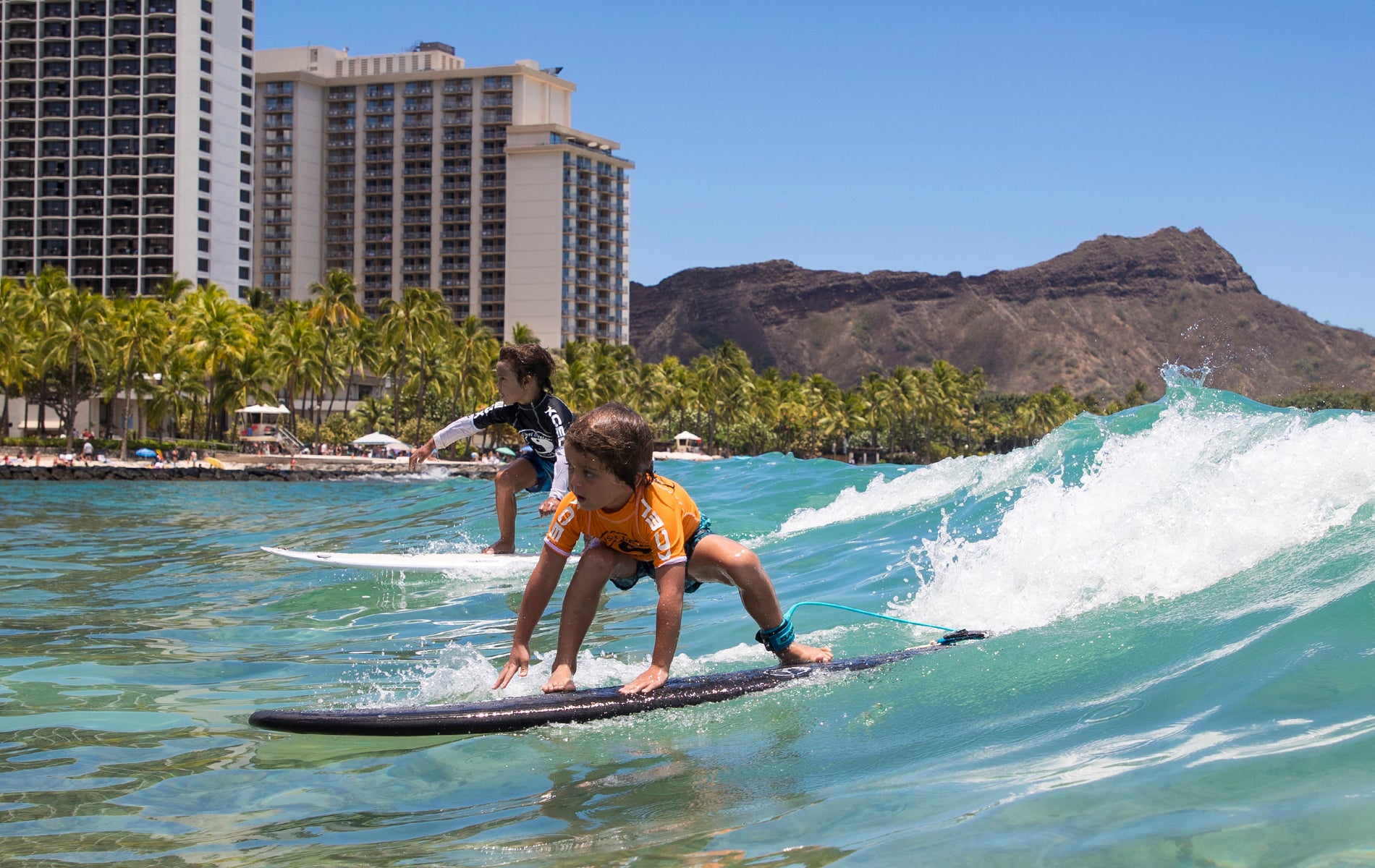 Kokua division competitors showcasing their skills in the T&C Surf Grom Contest
