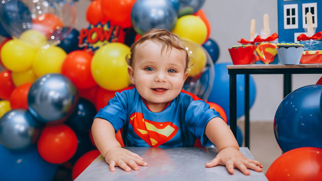 child celebrating the first birthday with a superhero theme