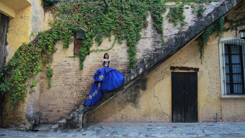 girl in blue quinceanera dress going up the stairs