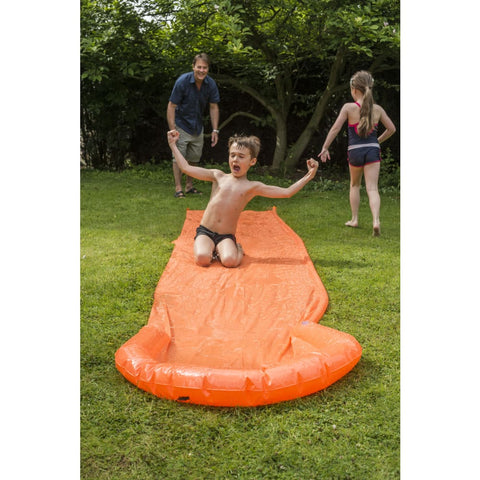 Kids and their dad playing in the garden on an orange slip and slide