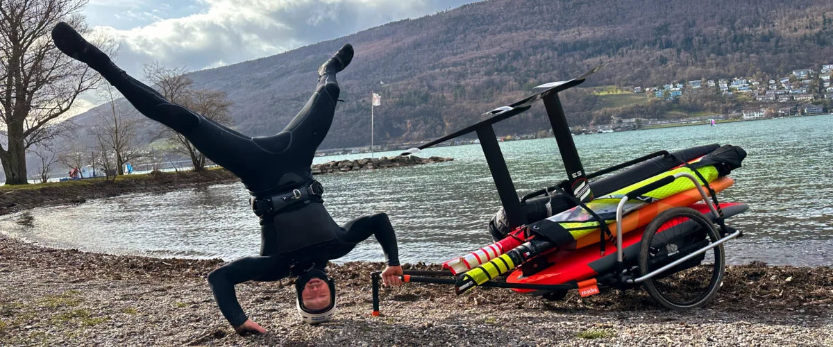 Le champion du monde de wingfoil Balz Müller avec sa remorque de vélo reacha