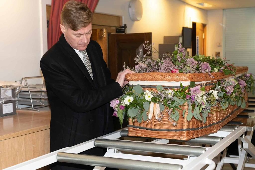 A Funeral Director moving the casket
