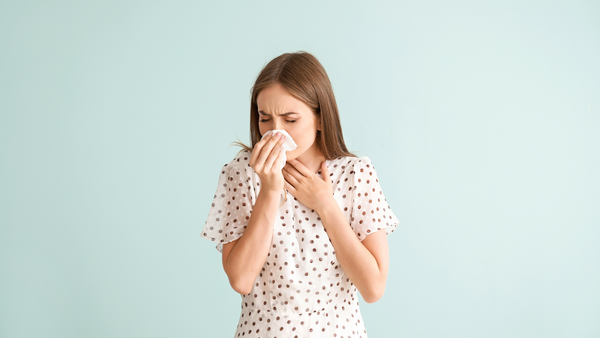 Woman blowing her nose into Kleenex 