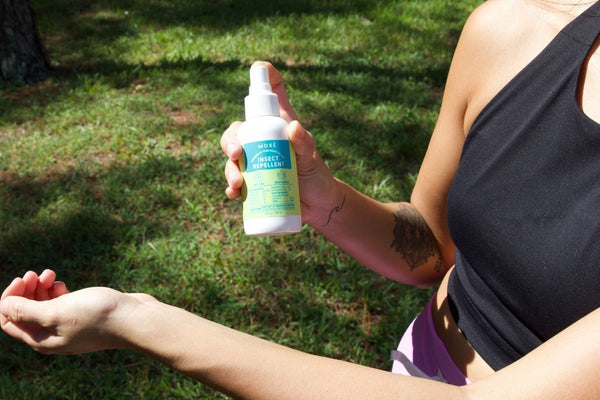 Girl spraying onto her arm the MOXĒ All-Natural Insect Repellent