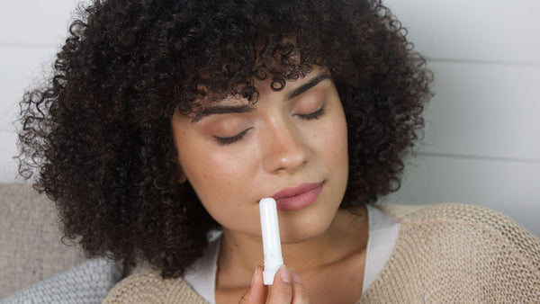 Woman smelling aromatherapy nasal inhaler 