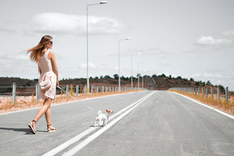 woman walking her dog to increase her activity level and using essential oils to help motivate her exercise routine