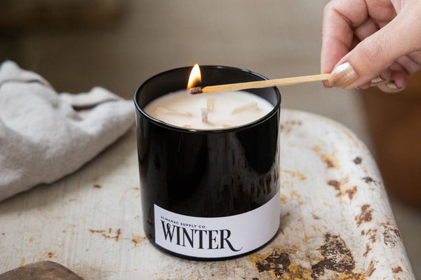 Long wooden match lighting Winter scented candle in black glass jar