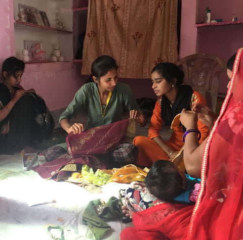 indian women sewing on the floor