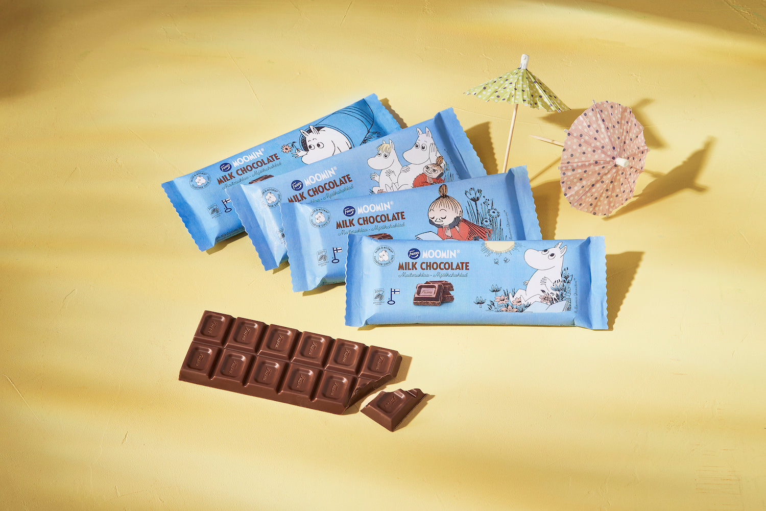 Four bars of Moomin chocolate in their wrappers and one open chocolate bar 