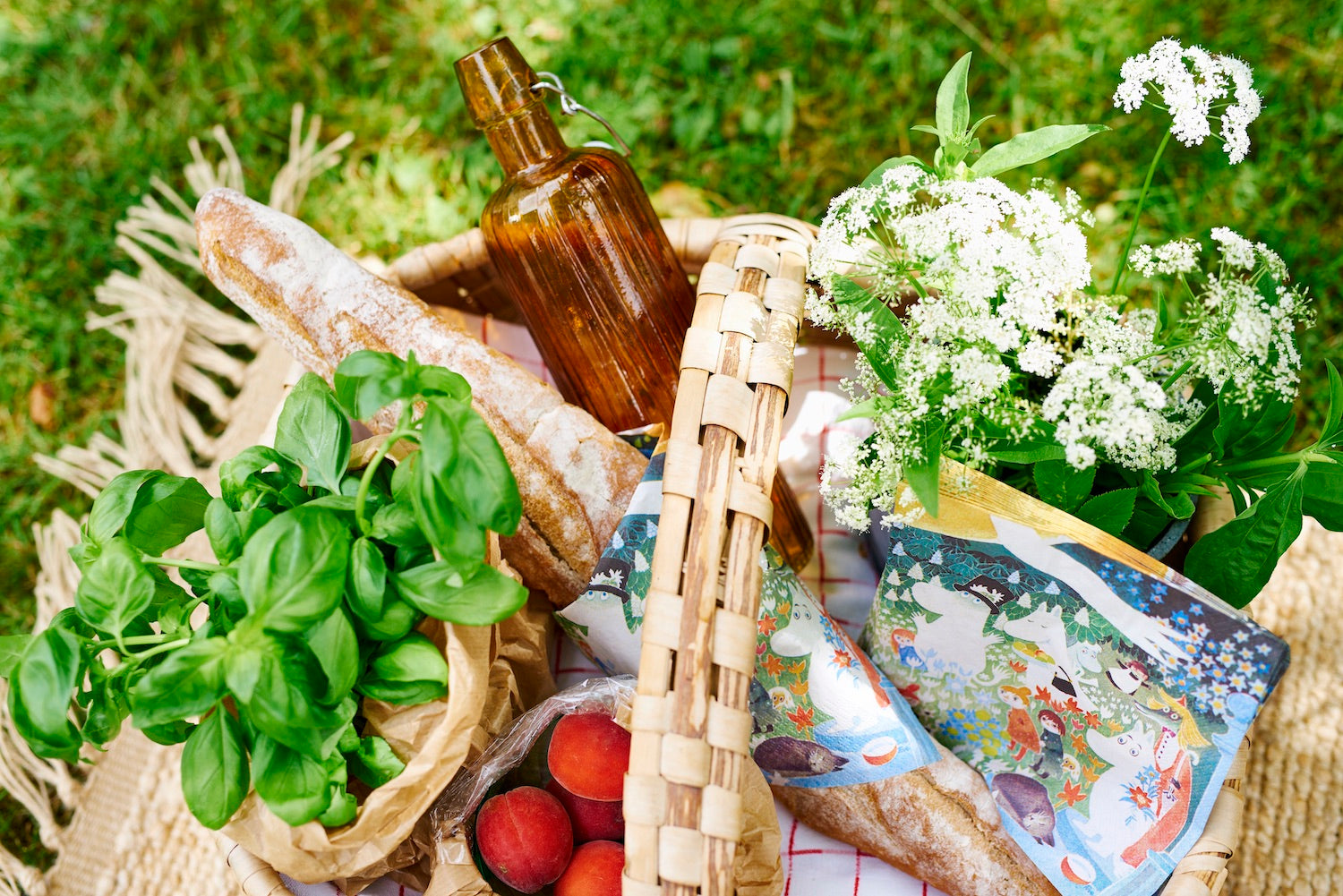 picnic basket with bread, herbs and Moomin napkins