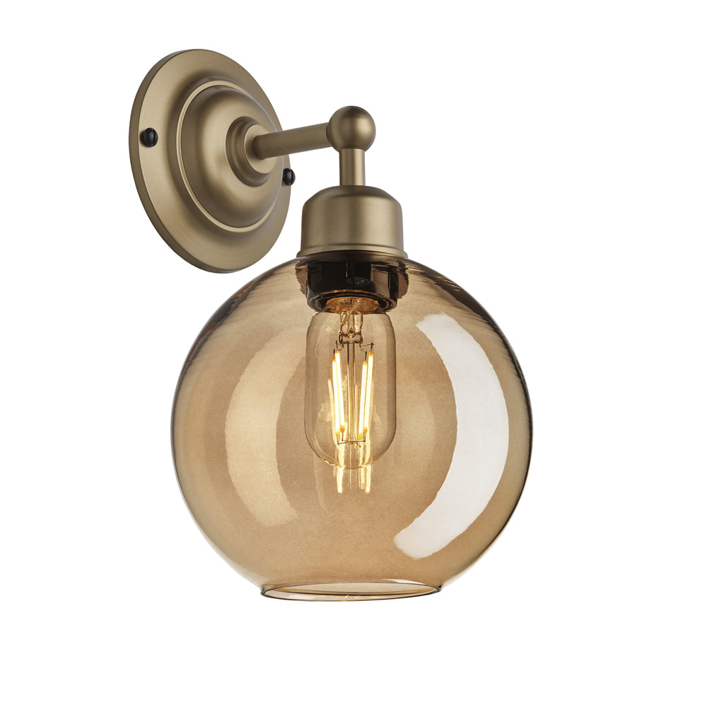 Product photograph of Industville Orlando Tinted Glass Globe Amber Wall Light 7 Inch Brass Holder from Olivia's